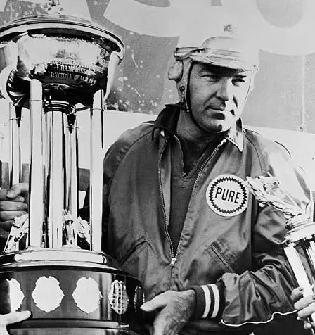  Curtis Turner race car driver holding his trophy and still wearing his helmet.
