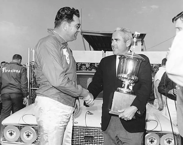 Curtis Turner (left) accepts the trophy for winning the first Permatex 300 at Daytona Beach, Florida on February 26,1966 from Pete Benoit, President of Permatex.