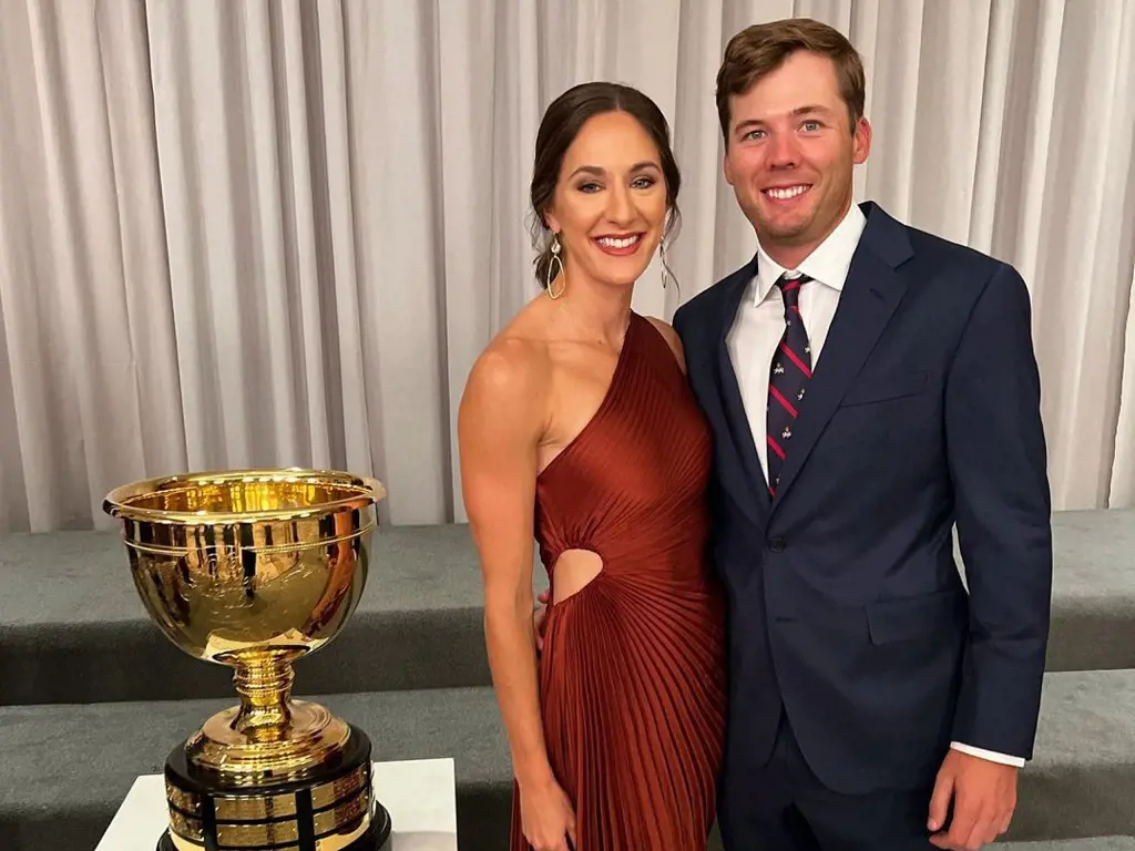 Sam Burns and his gorgeous wife Caroline Campbell posing beside the Presidents Cup.