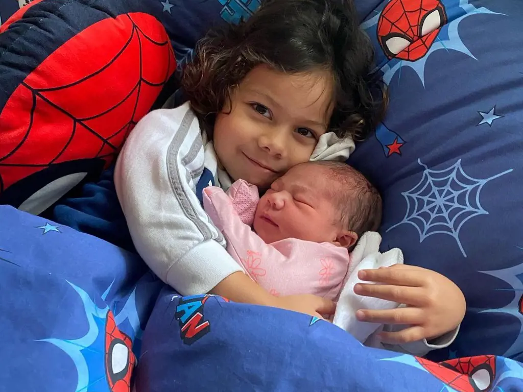 Israel Luai embracing his baby sister Akira.