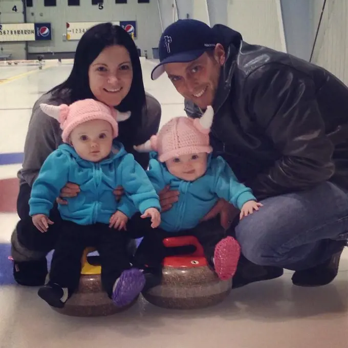 Kamryn and Khloe pictured sitting on curling stones as they are held by their parents in 2014