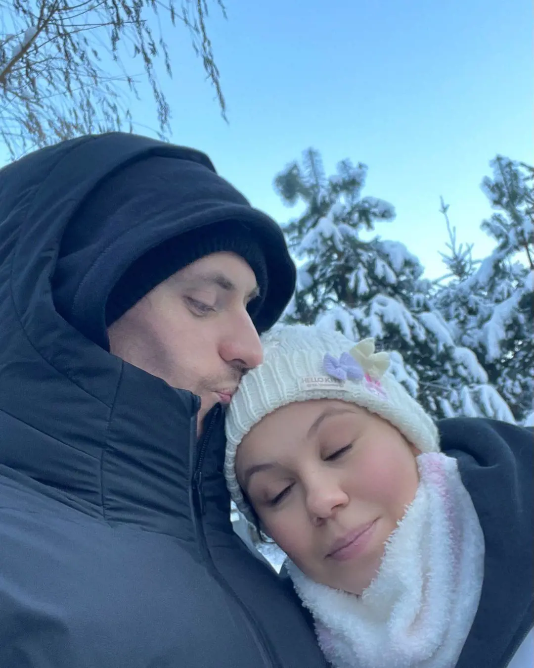 Sergei kissing on his girlfriend Elena's forehead in the cold afternoon of Christmas 2021 in Moscow.