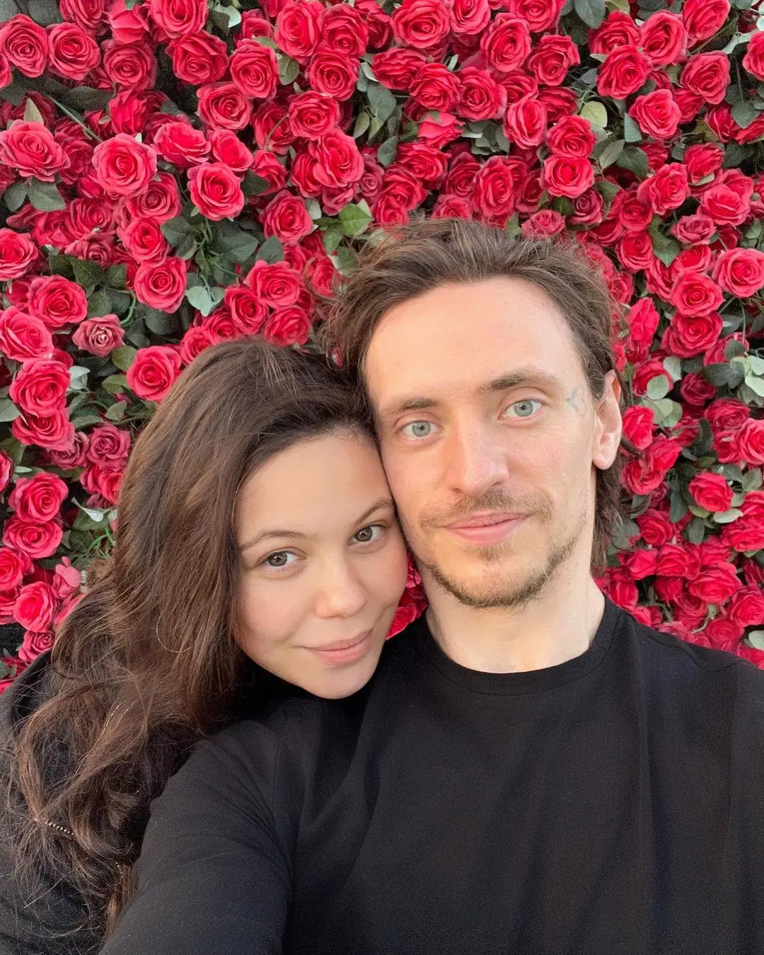 Sergei and Elena poses in front of roses on Valentine's Day in February 2022.