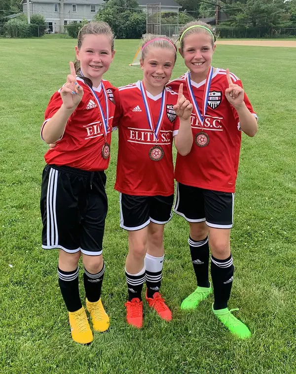 Freya(left) with her friends raises her finger indicating winning the first position at their soccer tournament 
