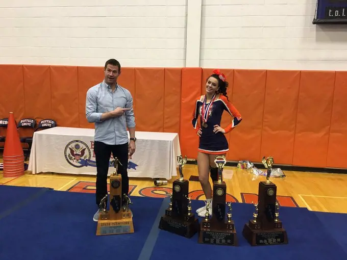 Brian McBride points towards his daughter Ashley as she showcases her accolades which she won as a cheerleader