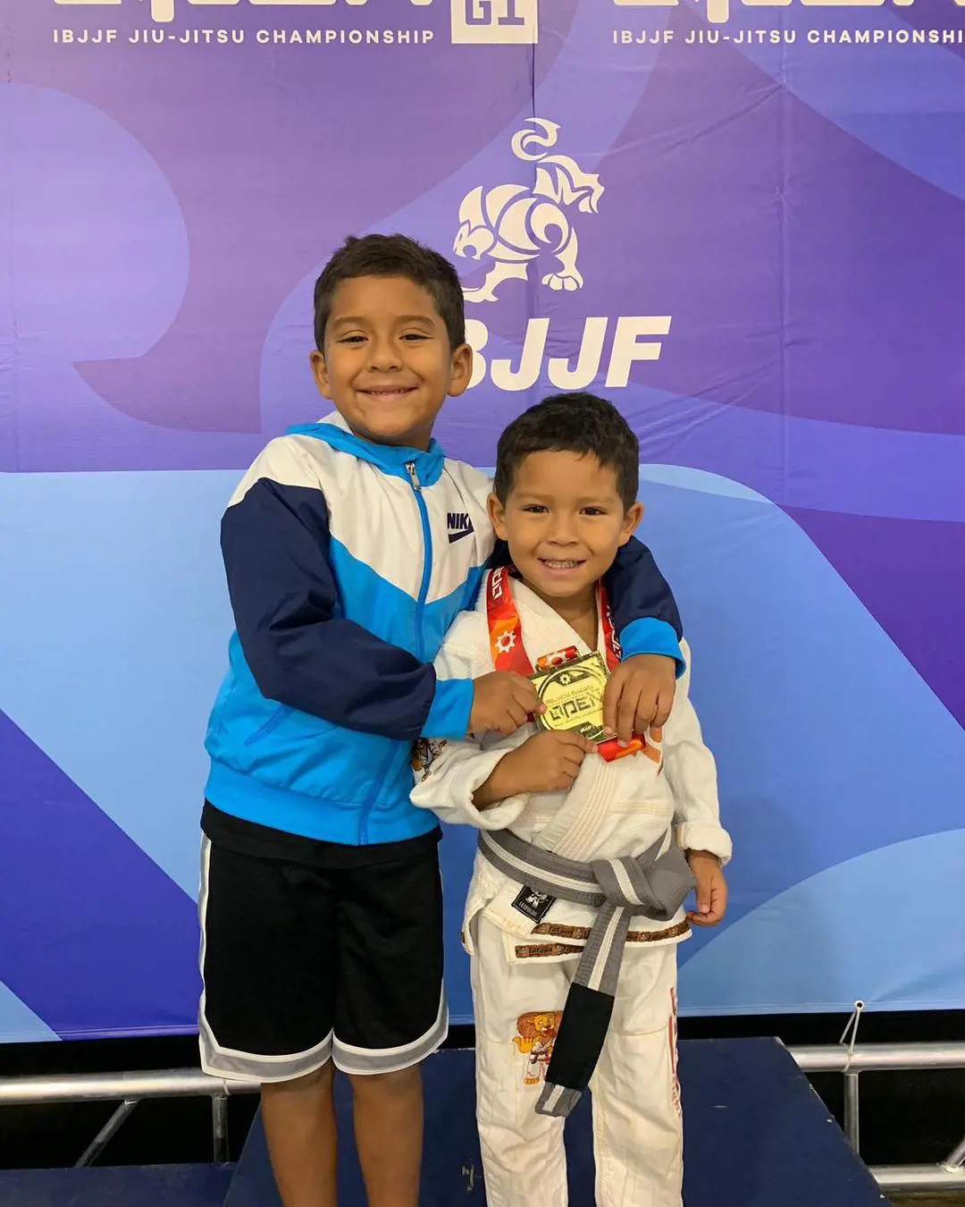 Joshua(right) shows his gold medal as he poses with his brother Pedro